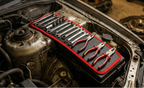 Tapis aimanté long fixé sur une aile de voiture avec des clés à portée de main