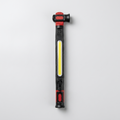 Lampe d'atelier LED COB noire et rouge vue de face, bandeau lumineux central allumé et bouton d'alimentation