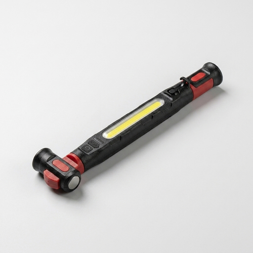 Lampe de travail LED COB rouge et noire posée à plat, bandeau lumineux allumé, avec crochet pliable et base magnétique